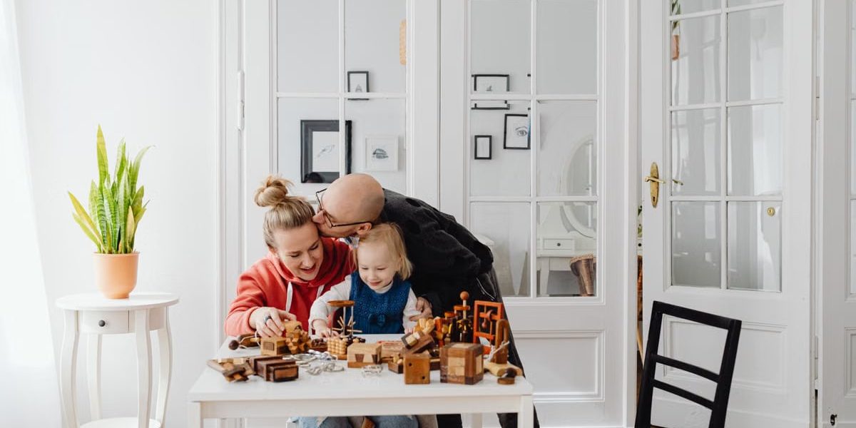 A loving family enjoying playtime with wooden toys in a cozy indoor setting.